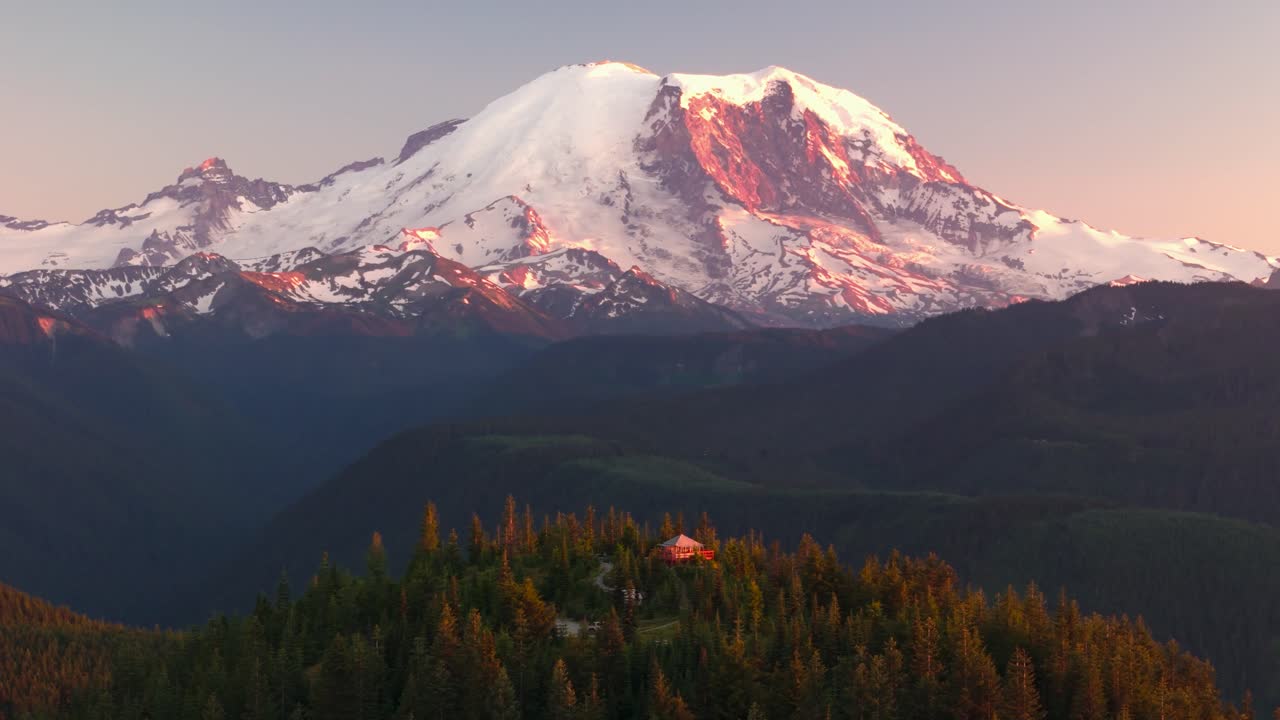 Drone shot of Mount Rainier during sunset with a fire lookout in the foreground