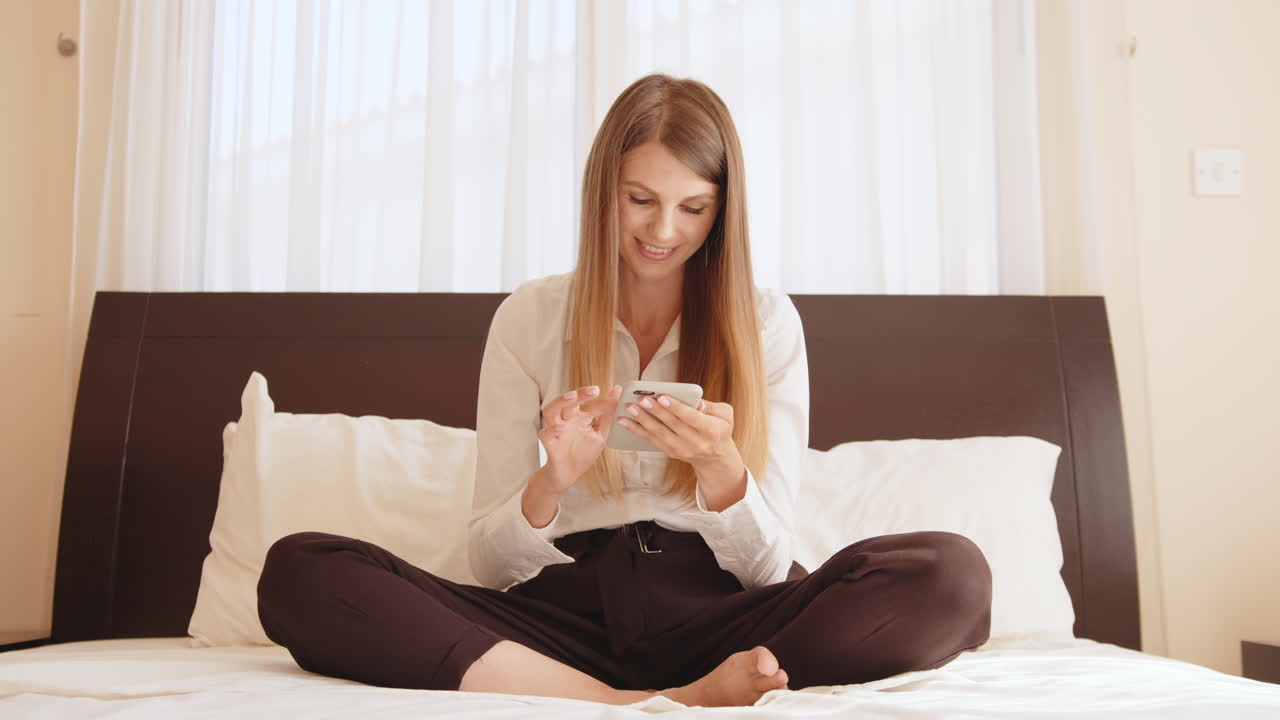 침실 에서 전화 를 사용하는 여자