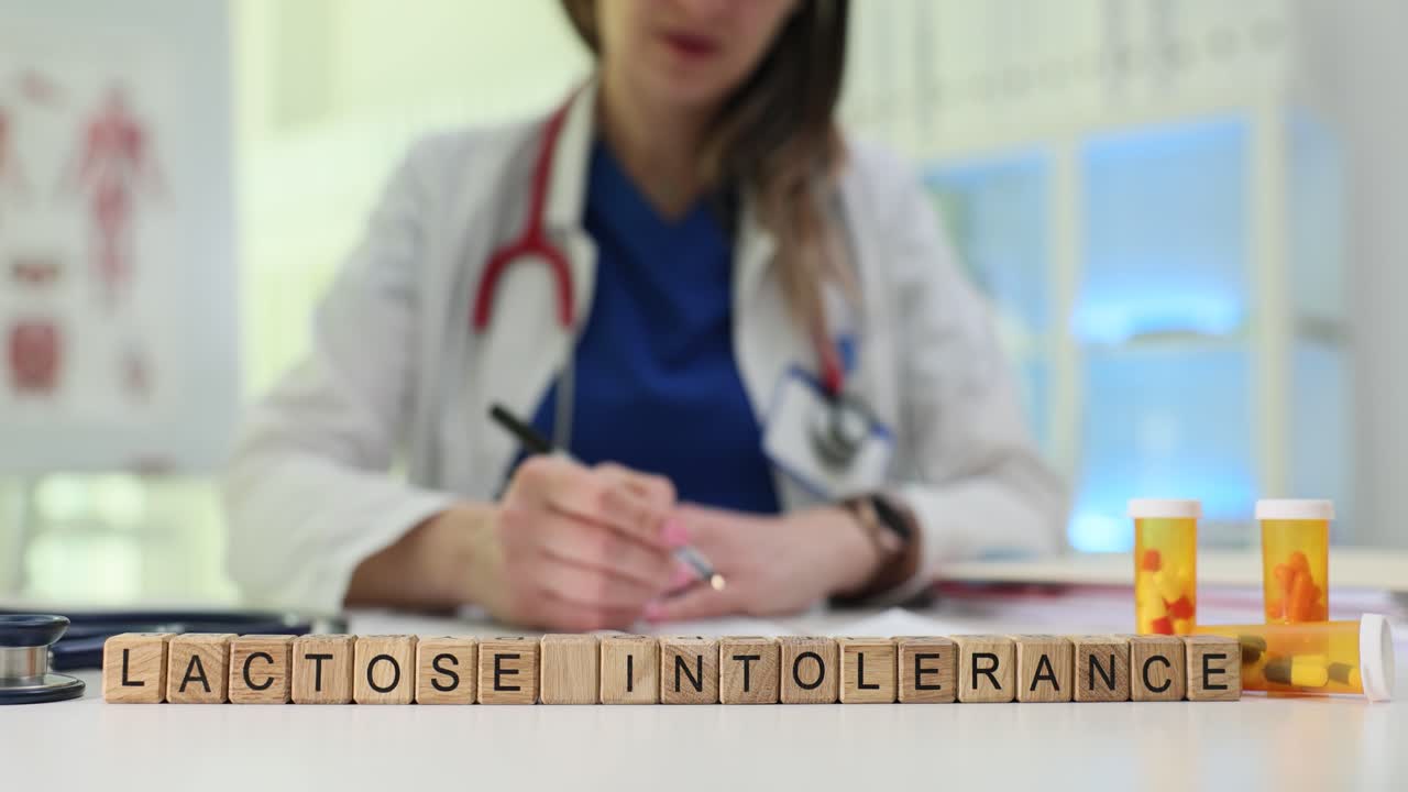 Cubetti di legno sul tavolo formano la frase 'intolleranza al lattosio' spiegata dal medico.