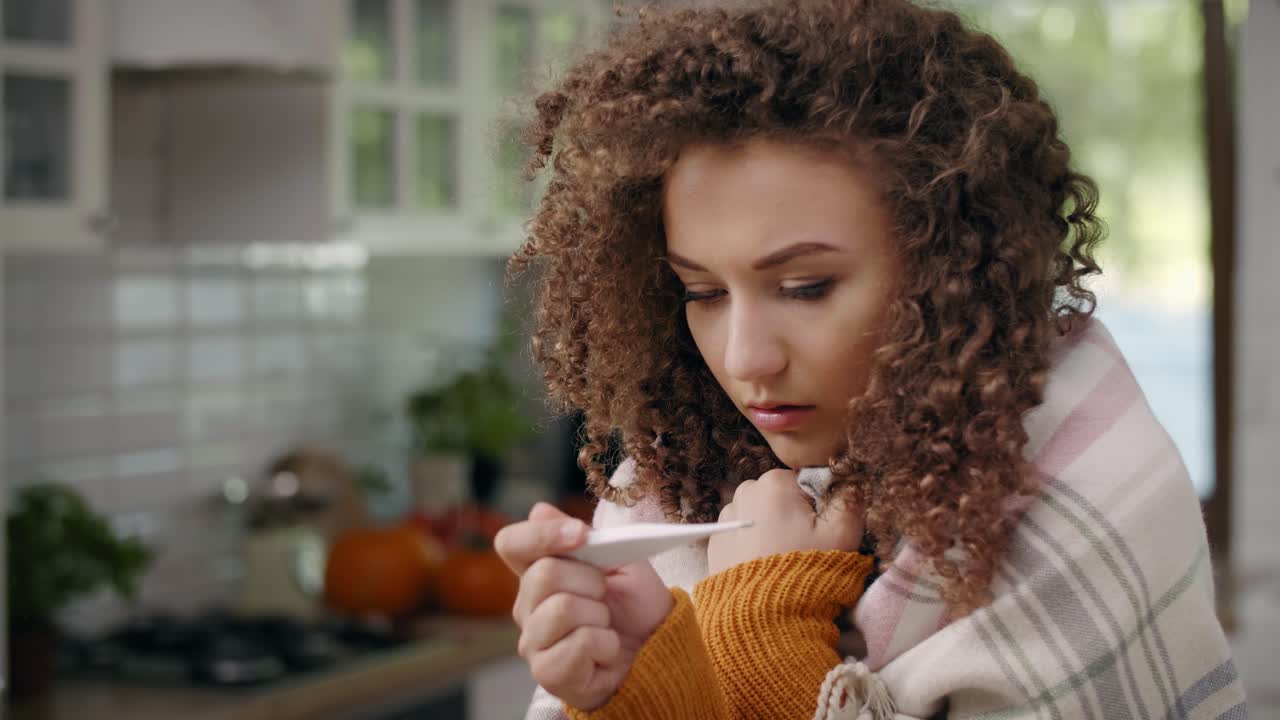 Zieke vrouw met thermometer die temperatuur meet/Rzeszów/Polen