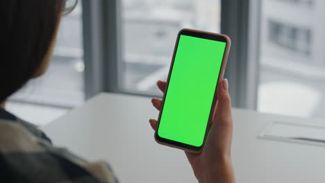 Hände-Einer-Dame-Halten-Ein-Greenscreen-Smartphone-Im-Haus.-Händler-Liest-Handy