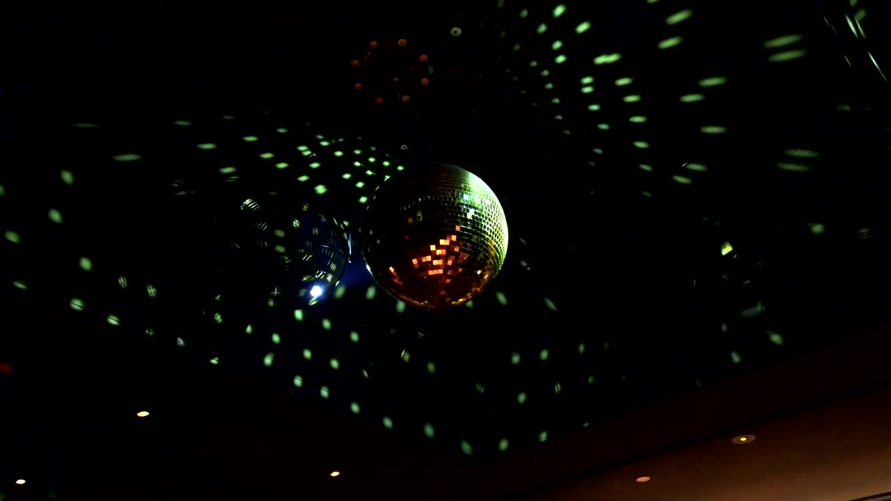 Una palla da discoteca in una discoteca che riflette giochi di luce.