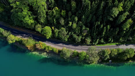 a road winds along the banks of attersee lake, austria - aerial