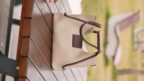 beige leather tote bag on wooden table
