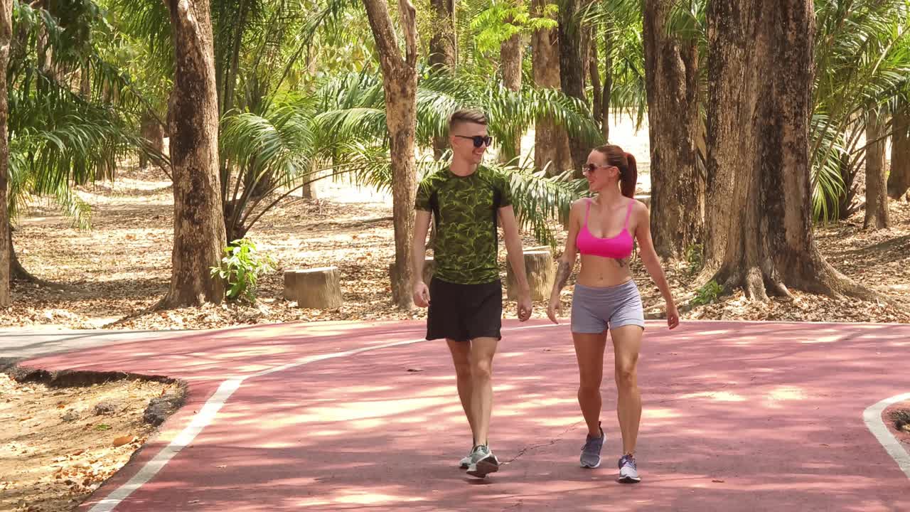 Una pareja caminando en un parque.