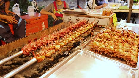 quail skewers grilling at a bangkok market