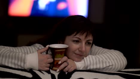 happy woman dreams about something at home in the evening, thinking about, drink a cup of cofee