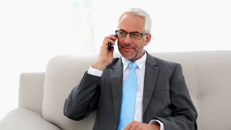 hombre de negocios hablando por teléfono en el sofá