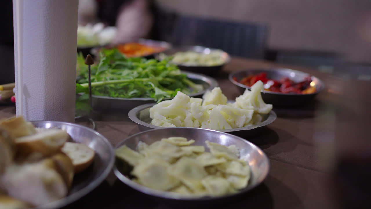 Traditional accompaniments for Argentine Bagna Cauda, bread, cheese, pasta and vegetables on table