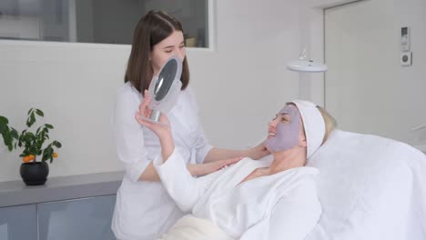 vrouw die een gezichtsmaskerbehandeling krijgt