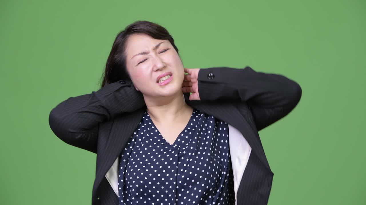 Mature beautiful Asian businesswoman having neck pain
