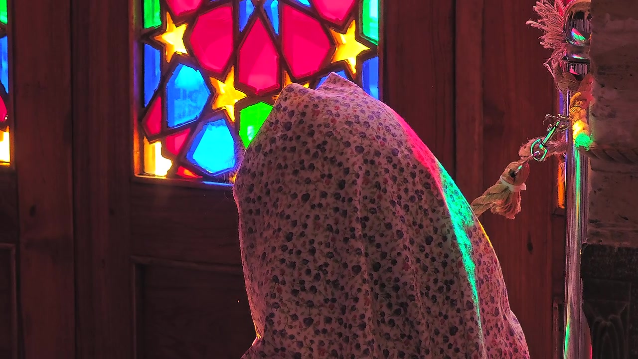 Mulher de Lenço na Cabeça Orando em Frente a uma Janela de Vitral
