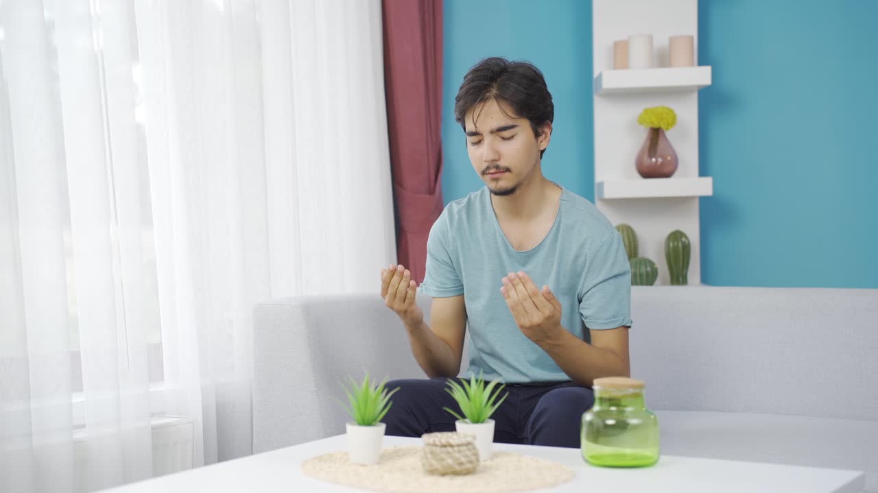 무슬림 남자가 창문 앞에서 기도하고 있습니다.