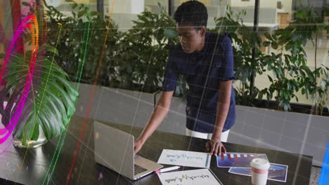 animation of financial data processing over african american businesswoman using laptop