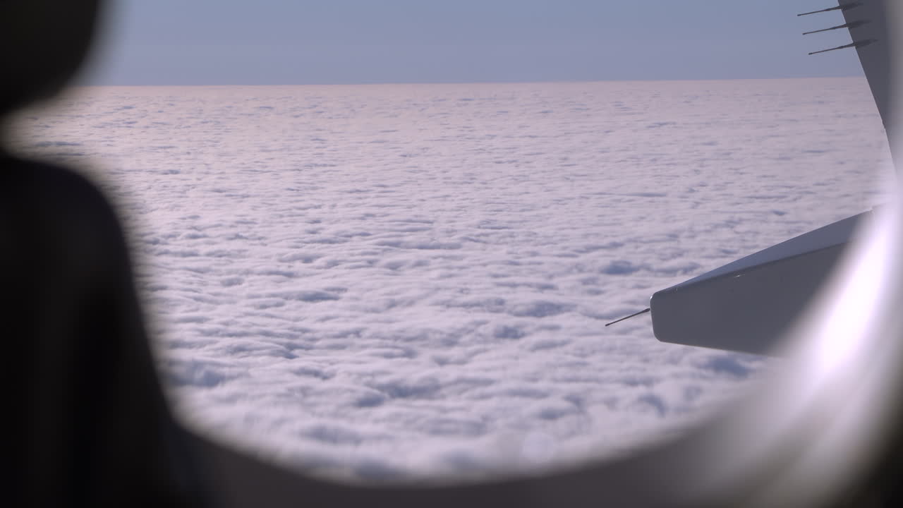 View from an airplane window of the fluffy clouds