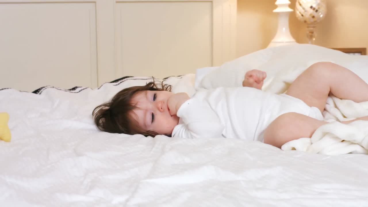 침대 위에서 놀고 있는 귀여운 아기