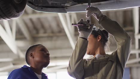 Video-of-two-diverse-female-car-mechanics-repairing-car