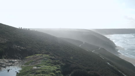 People-walking-the-Cornwall-coast-path-on-a-bright-and-windy-day-in-winter