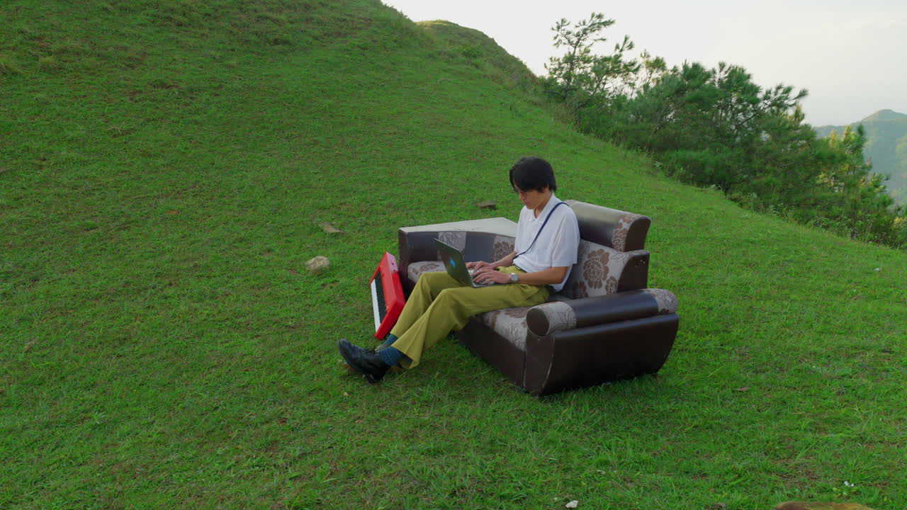 young musician sitting and working on laptop using AI to writing a new song in nature