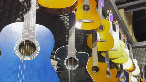 many colorful classical guitars hang on the wall in the shop.
