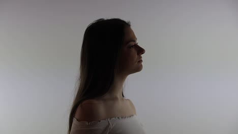 a silhouette of an attractive young caucasian woman in a white room