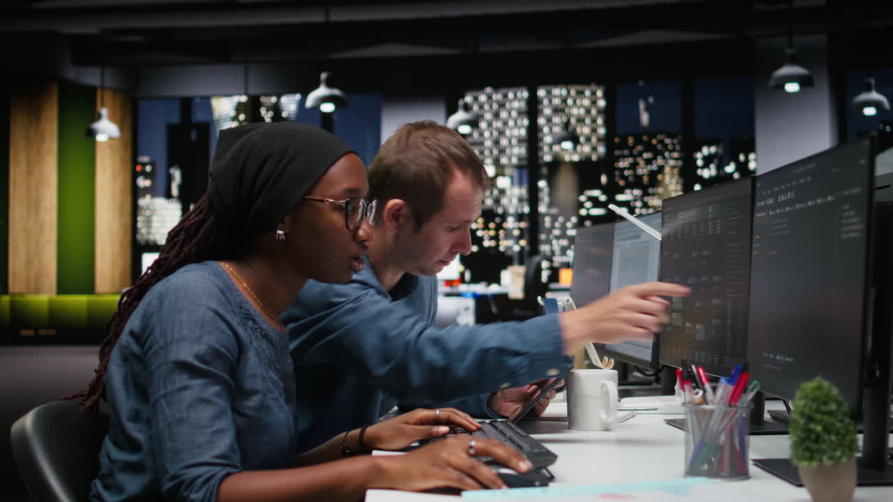 Diverse Software Developers Collaborating on Project in Modern Office at Night