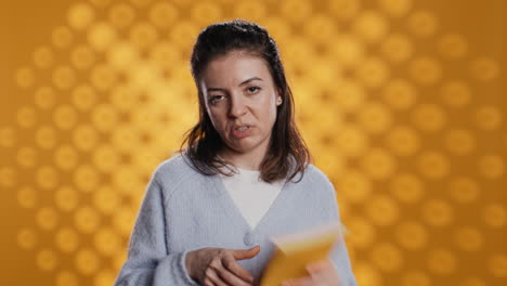 mujer decepcionada golpeando libro, mostrando pulgares hacia abajo señal, fondo de estudio