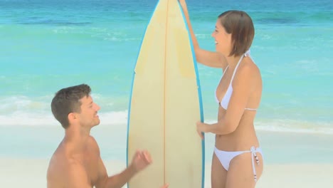 man proposing to girl with a surfboard