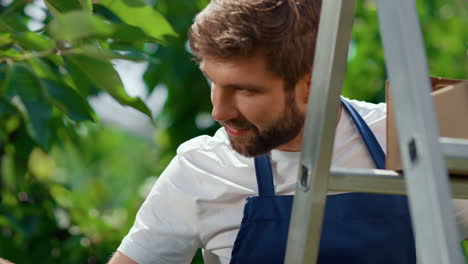 retrato de un agricultor recogiendo ramas de bayas en una plantación natural de tierras de cultivo sonriendo