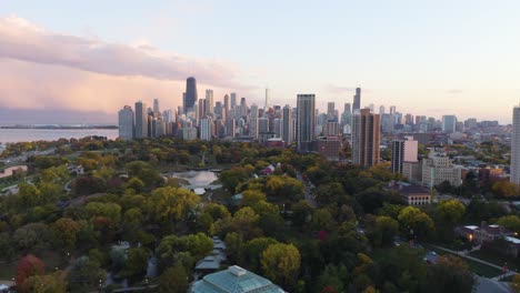 Toma-Aérea-Del-Parque-Lincoln-Y-El-Paisaje-Urbano-De-Chicago---Puesta-De-Sol-De-Otoño