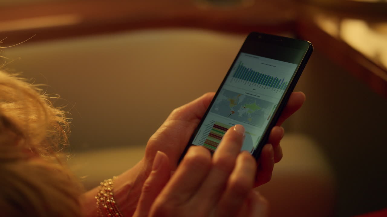 manos con gráficos de datos en un primer plano de teléfono celular. gerente desconocido trabajando en un viaje