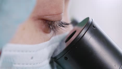 scientist looking through a microscope