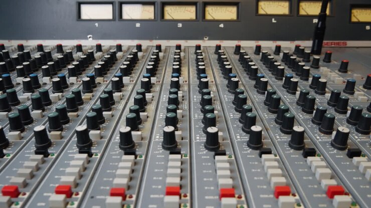 Close up of vintage audio mixing desk EQ pan pot knobs and buttons