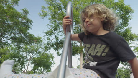 small girl spinning on a roundabout in a park