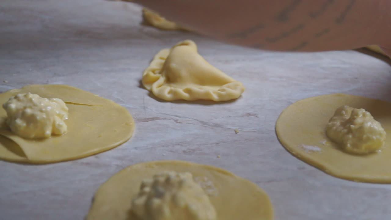 imágenes de primer plano de una mujer preparando pasteles de queso griego caseros