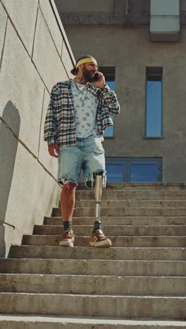 man with prosthetic leg talking on phone on stairs