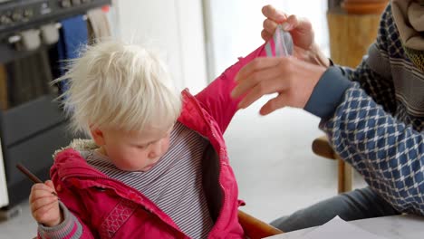 father helping his daughter to take off her jacket at home 4k