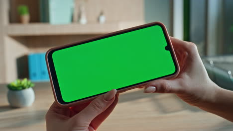 hands holding horizontal mockup mobile phone at corporate workplace close up.