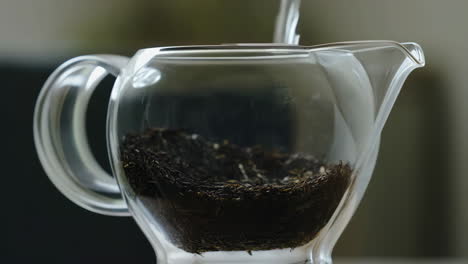 glass teapot with loose leaf tea and steam