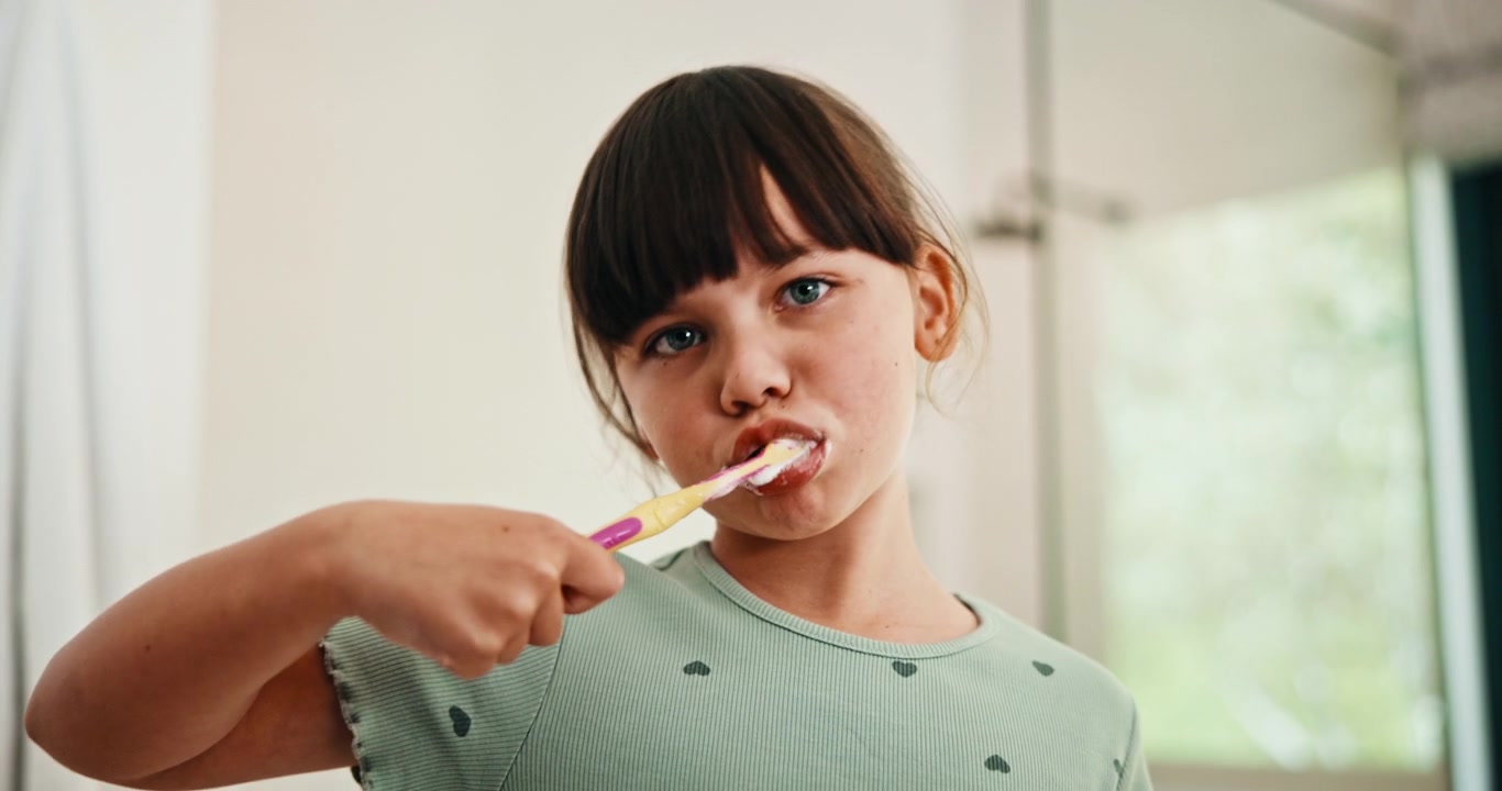 Young Girl Brushing Her Teeth in the Bathroom