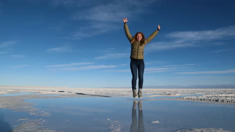 Woman Jumping with Joy on a Reflective Salt Flat