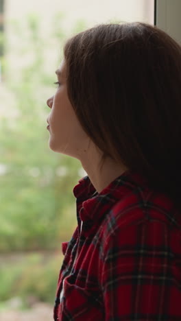 lonely woman rests near window. brunette lady thinks too much about relationship problems at home. patient mental health disorders need help of psychologist