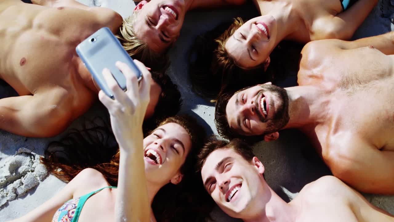 Grupo de amigos tomándose una selfie con el teléfono móvil