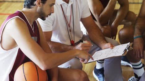 Coach-and-player-discussing-over-clipboard