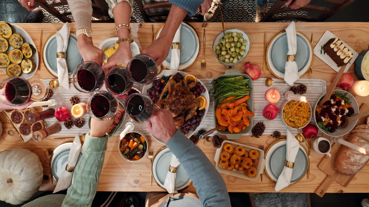 Overhead view of a Thanksgiving dinner table with people celebrating