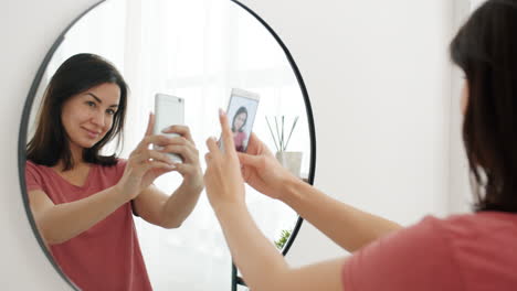 woman taking selfie in front of mirror