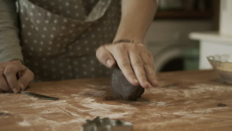 Hand-kneads-and-rolls-gingerbread-dough-on-kitchen-table,-medium