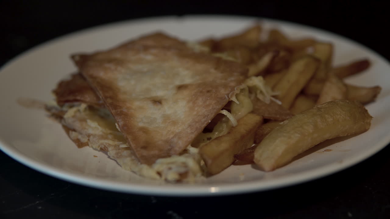 Close-up nachos and fires on white plate, pan camera moving