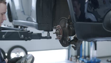 car mechanic working on disc brakes