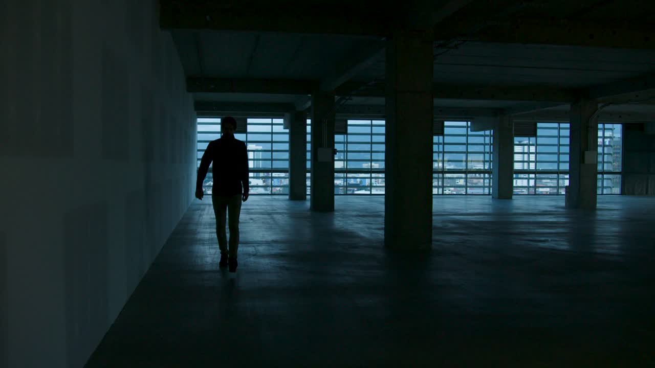 한 남자가 코스타리카 산호세 시의 공사 중인 사무실 바닥을 가로질러 걸어갑니다.